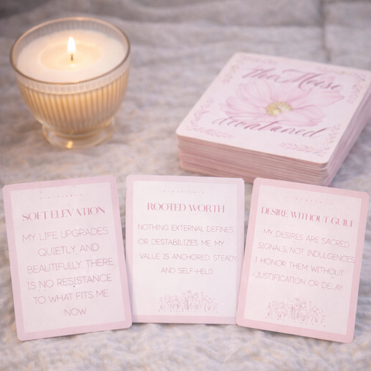 Stack of pink cards with text on a textured surface with a lit candle.